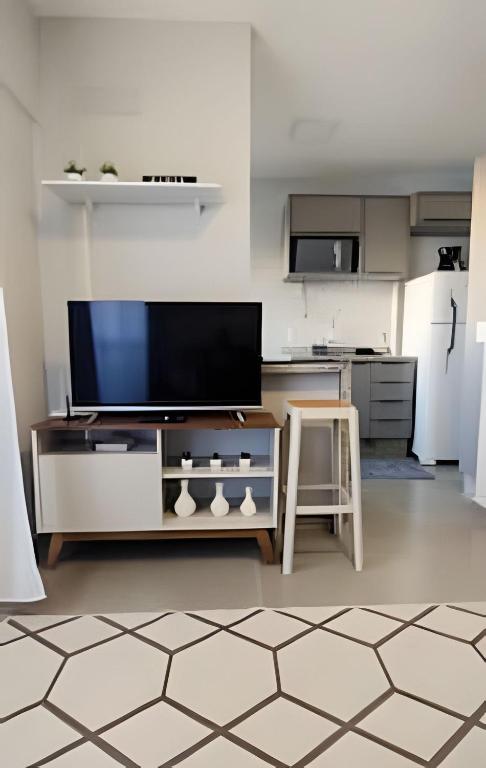 隆德里纳Apto com Wi-fi e garagem -的一间带电视和桌子的客厅以及一间厨房