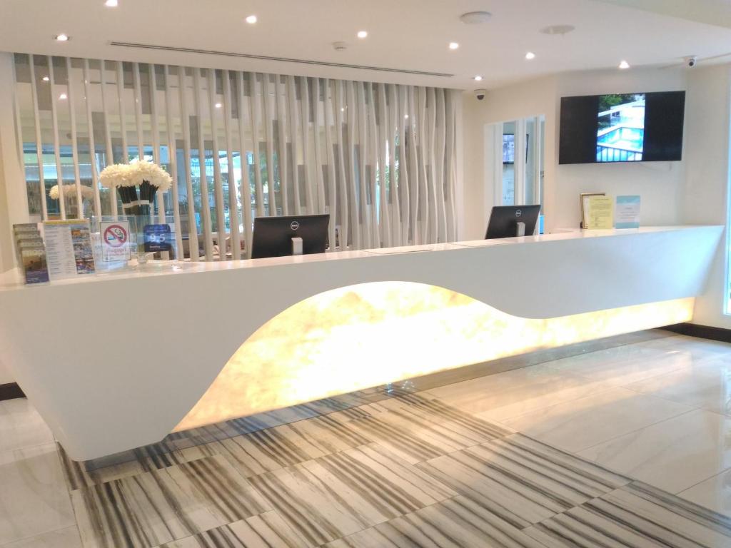 A modern reception desk with illuminated detailing and a striped rug.