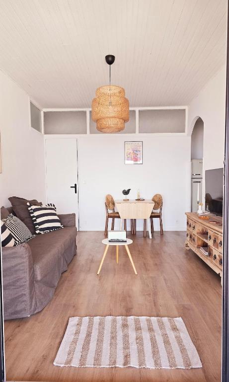 un salon avec une table et un canapé dans l'établissement Appartement vue sur le golf de Porto, à Porto Ota