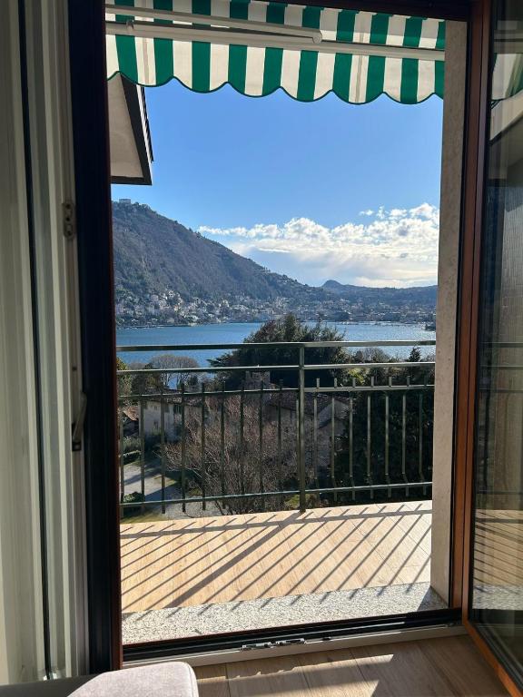 a door to a balcony with a view of the water at The VIEW - Spacious modern apt in Como