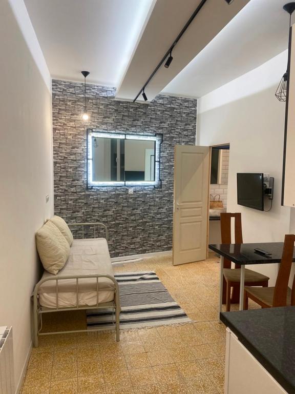 une chambre avec une chaise et une table ainsi qu'une cuisine dans l'établissement Nationale, à Nîmes