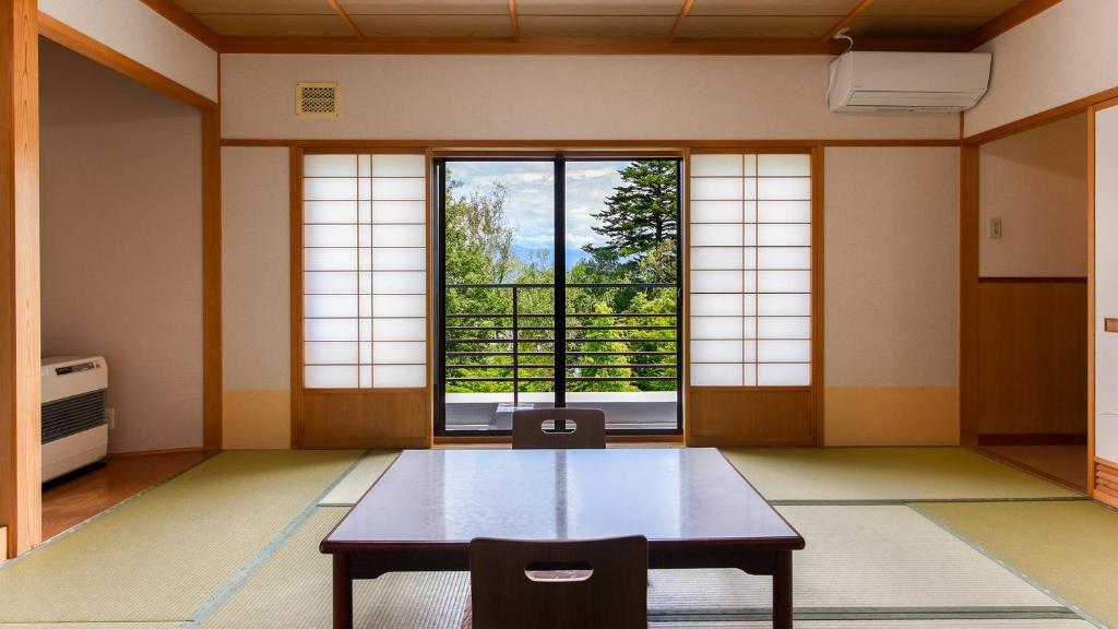 a room with a table and a large window at Hayataro Onsen Komagane Kogen Retreat Suzuran Haya - Vacation STAY 34206v in Komagane