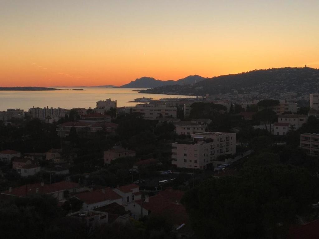 - une vue sur la ville au coucher du soleil dans l'établissement Joli cozy studio vue mer, à Antibes