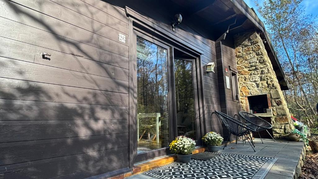 a house with a stone wall and a patio at Forest Lodge in Petit Mesnil