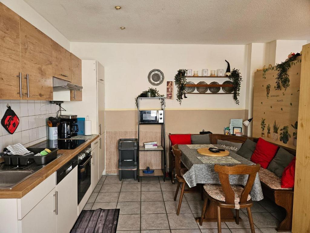 a kitchen and living room with a table and a couch at App-O1-2-3-Personen-23km-bis-Frankfurt-Nord in Ober-Mörlen