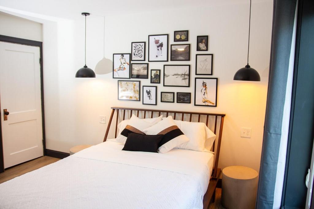 a bedroom with a white bed with pictures on the wall at 5 Minutes to the Falls-Luxury Home 3BR 2 Bath - USA Side in Niagara Falls