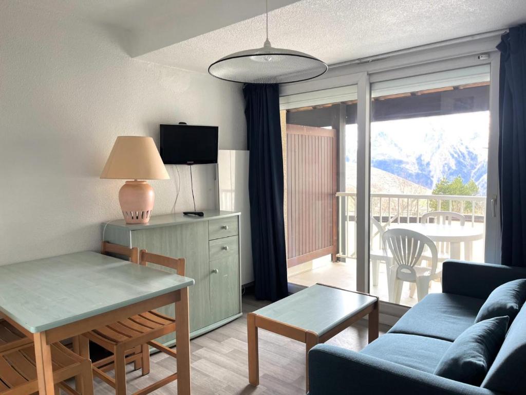 a living room with a blue couch and a table with a table at Résidence Balcons Du Soleil 1 - T2/4pers BALCONS DU SOLEIL 12-Peyresourde MAE-9954 in Germ