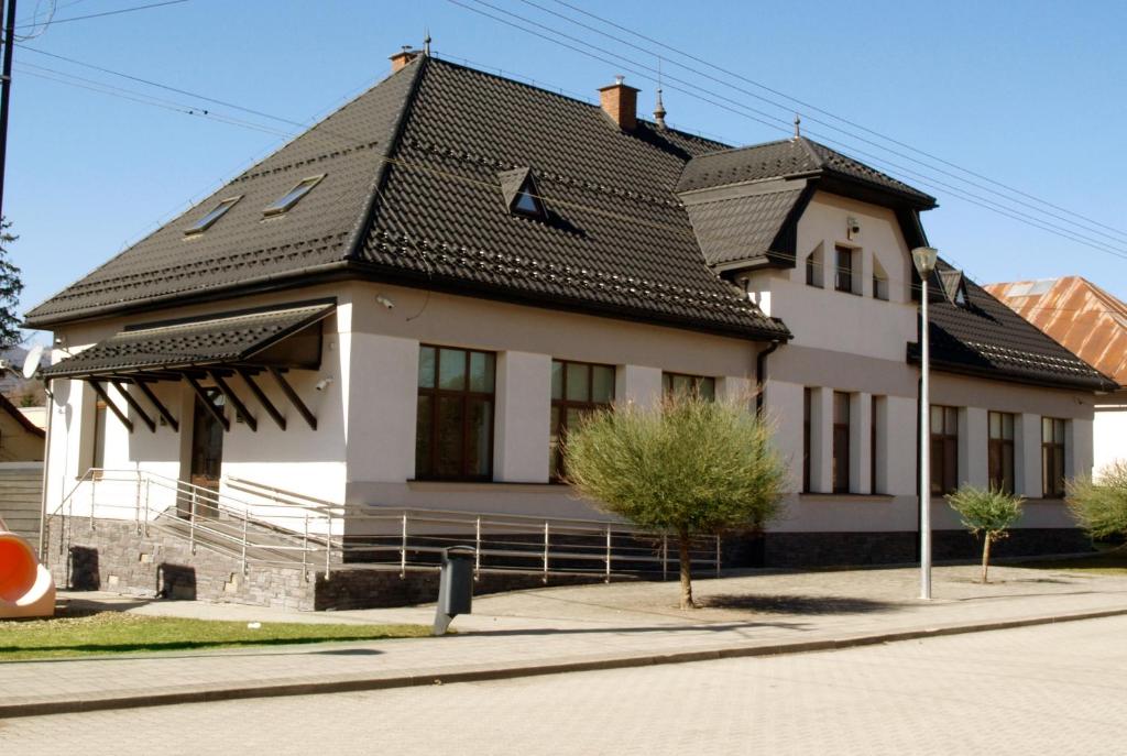 una gran casa blanca con techo negro en Apartmánové byty so saunou a vírivkou, en Predajná