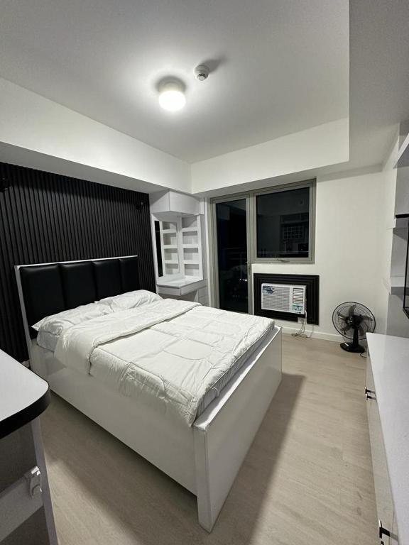 PampangにあるJPC Skyline Condo in Azure pampangaの大きなベッドと暖炉のある寝室