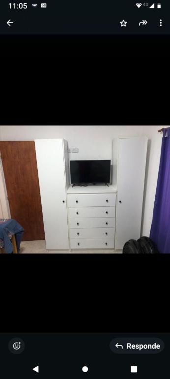 einen weißen Schrank mit einem TV in einem Zimmer in der Unterkunft Casla in San José