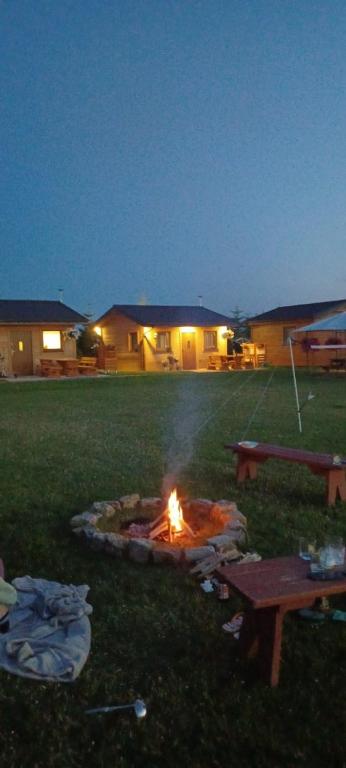 a fire pit in the middle of a yard at night at Domki Pod Brzozami in Sarbinowo