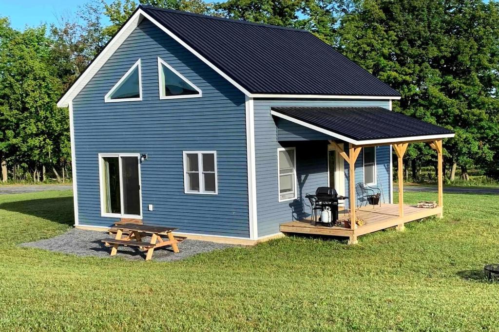 una casetta blu piccola con portico e griglia di Farmhouse cottage close to Smugglers Notch a Cambridge