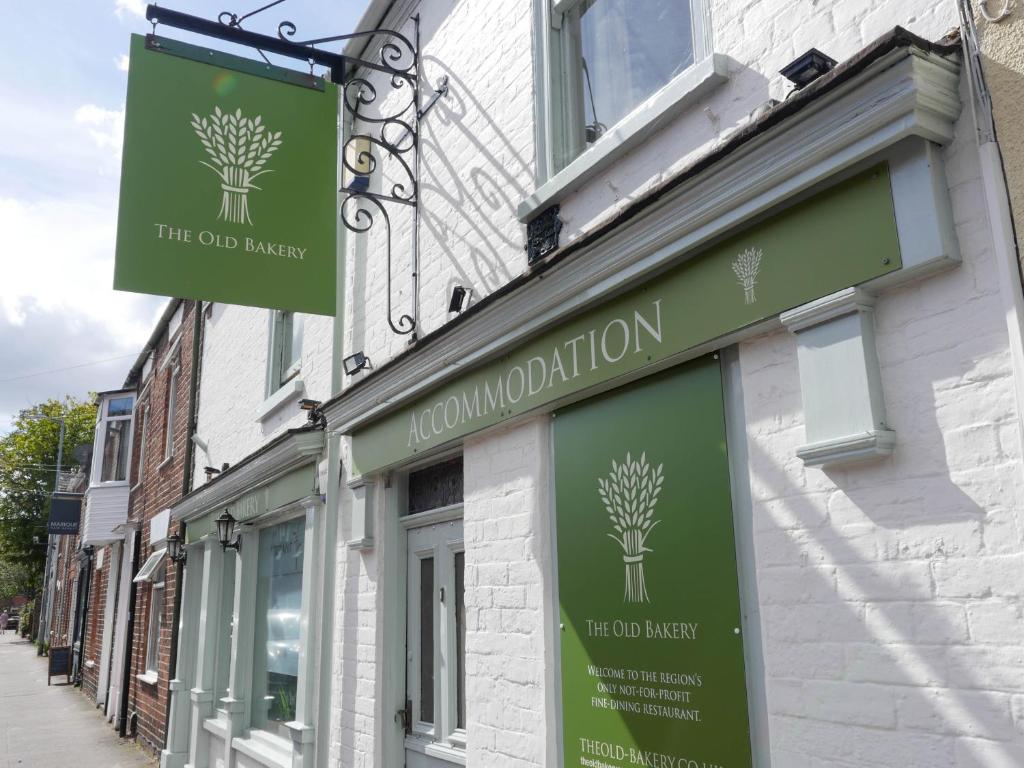 a building with green signs on the side of it at The Old Bakery in Lincoln