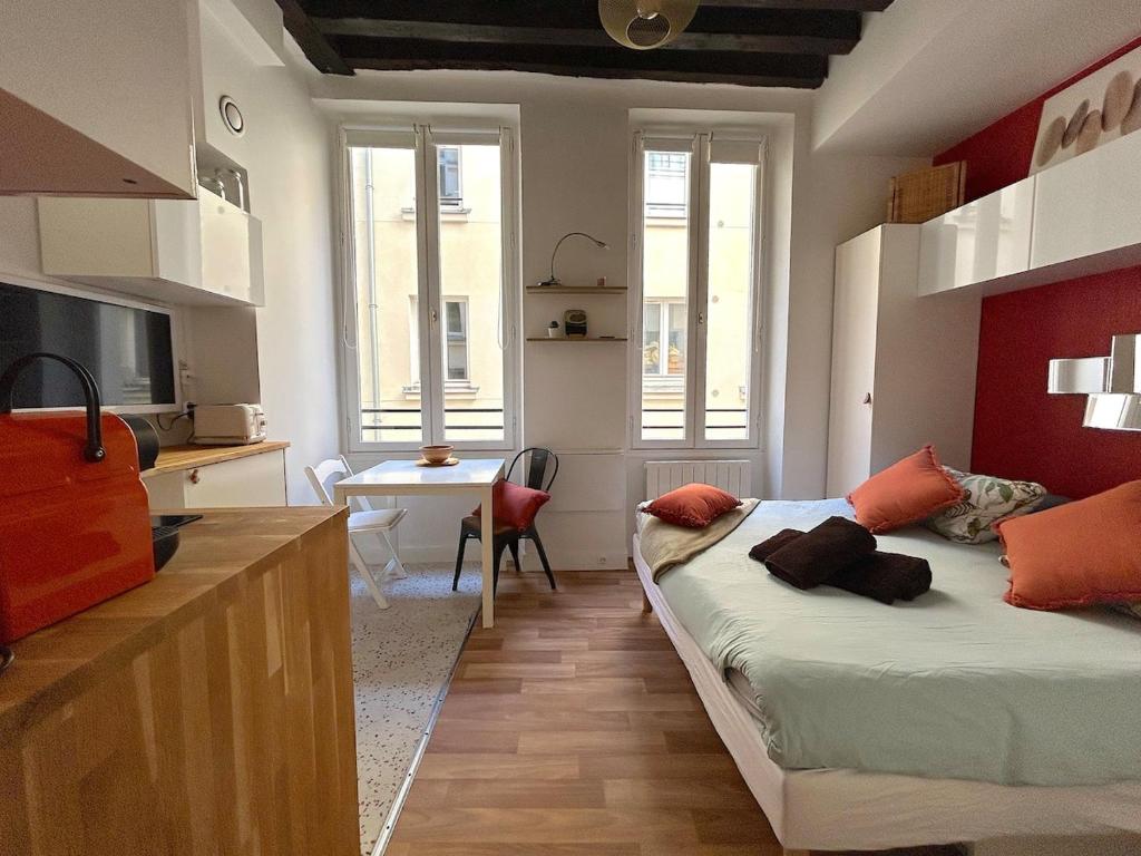 une chambre avec un lit et un bureau dans une pièce dans l'établissement Large studio - heart of Paris, à Paris