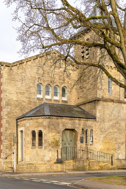 an old brick building with a door on a street at Belle-Suite - Charming Cotswolds Historic Apartment in Stow-on-the-Wold in Stow on the Wold