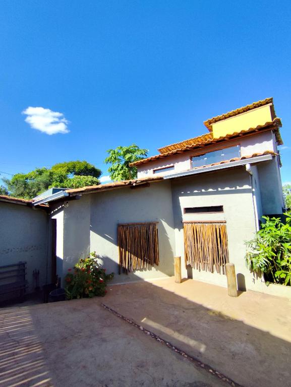 una casa bianca con due porte e un cancello di Flor do Cajueiro a Lençóis