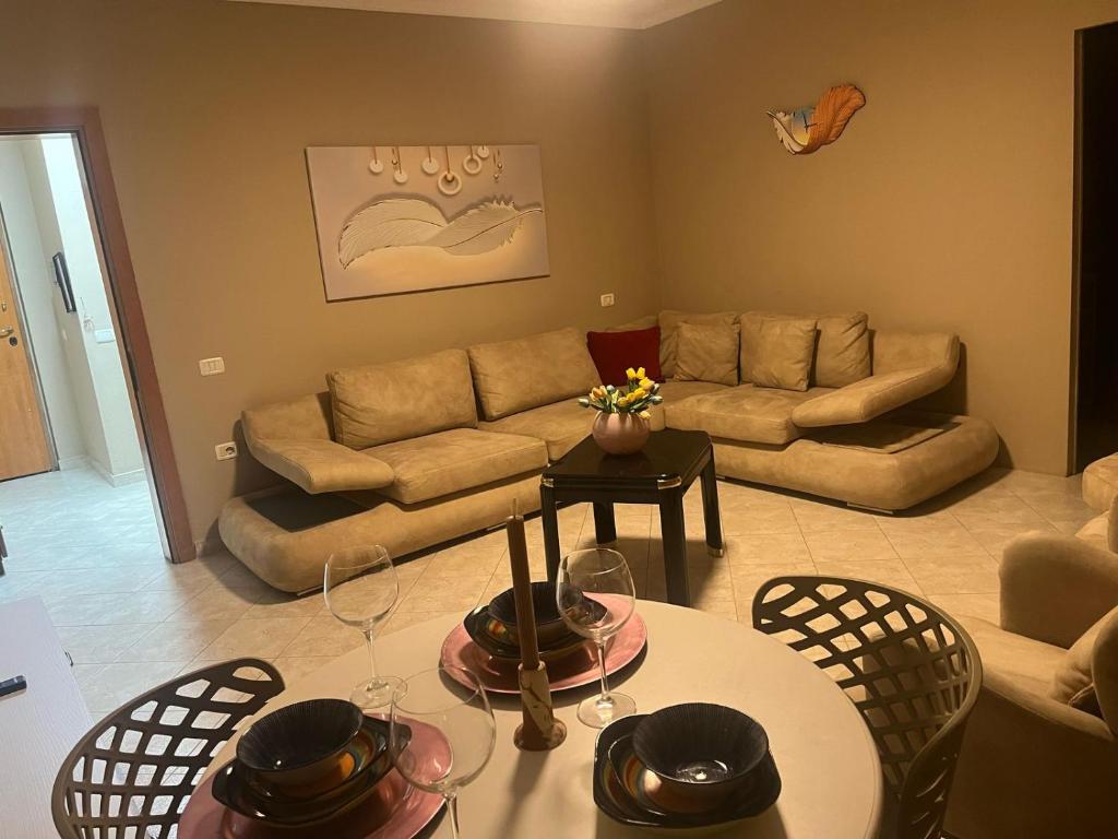 a living room with a couch and a table and chairs at Velora Apartment in Tirane