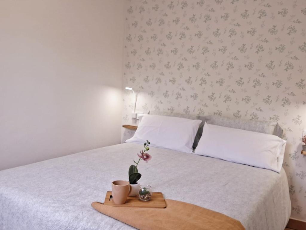 a bed with a tray with a flower on it at Apartamento en el centro recién reformado in Santander