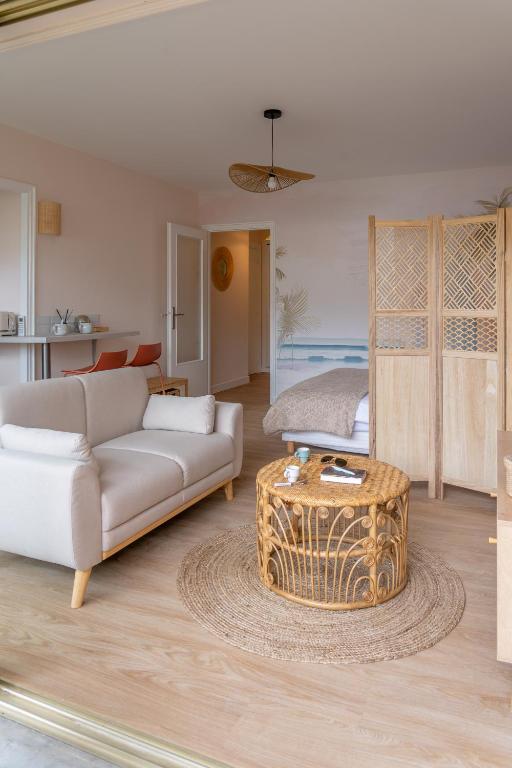 un salon avec un canapé et une table dans l'établissement Centre-Ville Le Cannet - Piscine, Tennis, Parking - À 10 min de la Croisette ! - Azur Eden, au Cannet