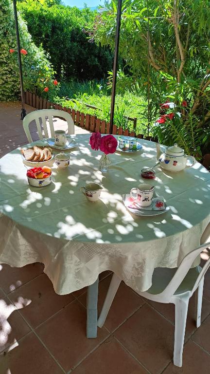 une table avec des tasses et des bols de nourriture dans l'établissement Les Tourterelles, à Cadolive