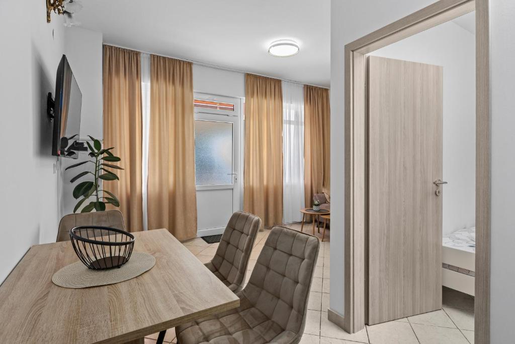 Una sala de estar con mesa de comedor y sillas. en New Apartment Lejla, en Šišan