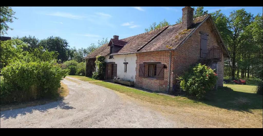 une vieille maison en briques assise sur un chemin de terre dans l'établissement Gîte privée piscine 1h de beauval, à Nouan-le-Fuzelier