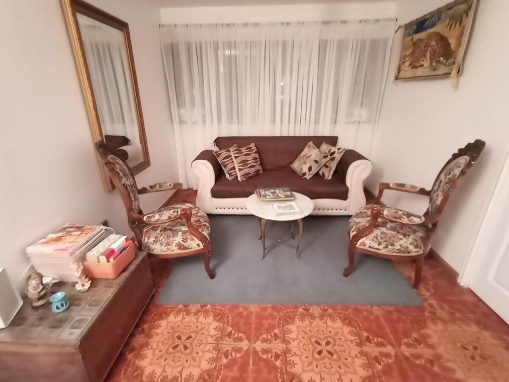 a living room with a couch and a table and chairs at Departamento en playa blanca in Antofagasta