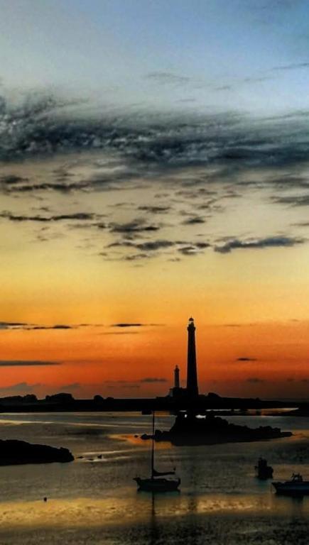 un phare assis dans l'eau au coucher du soleil dans l'établissement hébergement Mézéozorn, à Plouguerneau