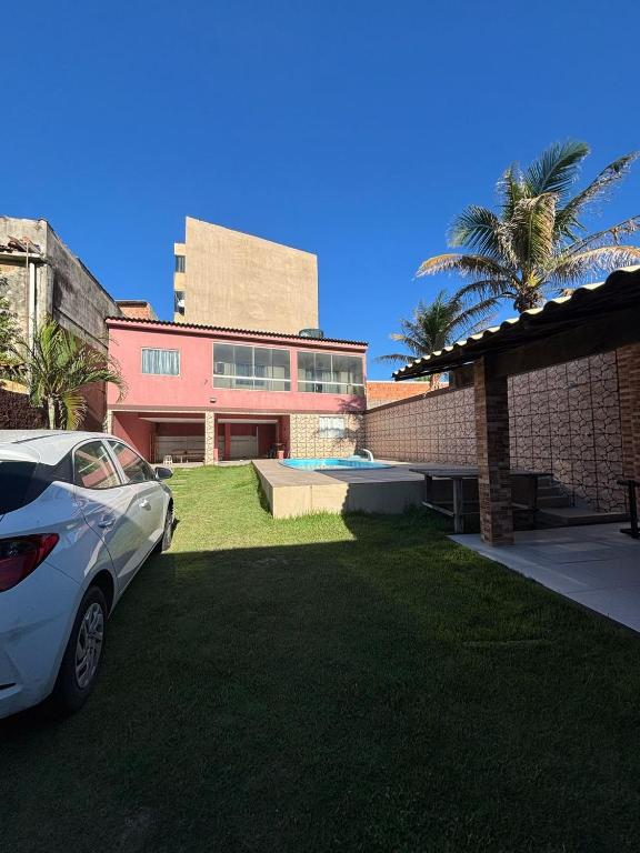 Un coche blanco aparcado delante de un edificio en Recanto dos Monteiros, en Vila Velha