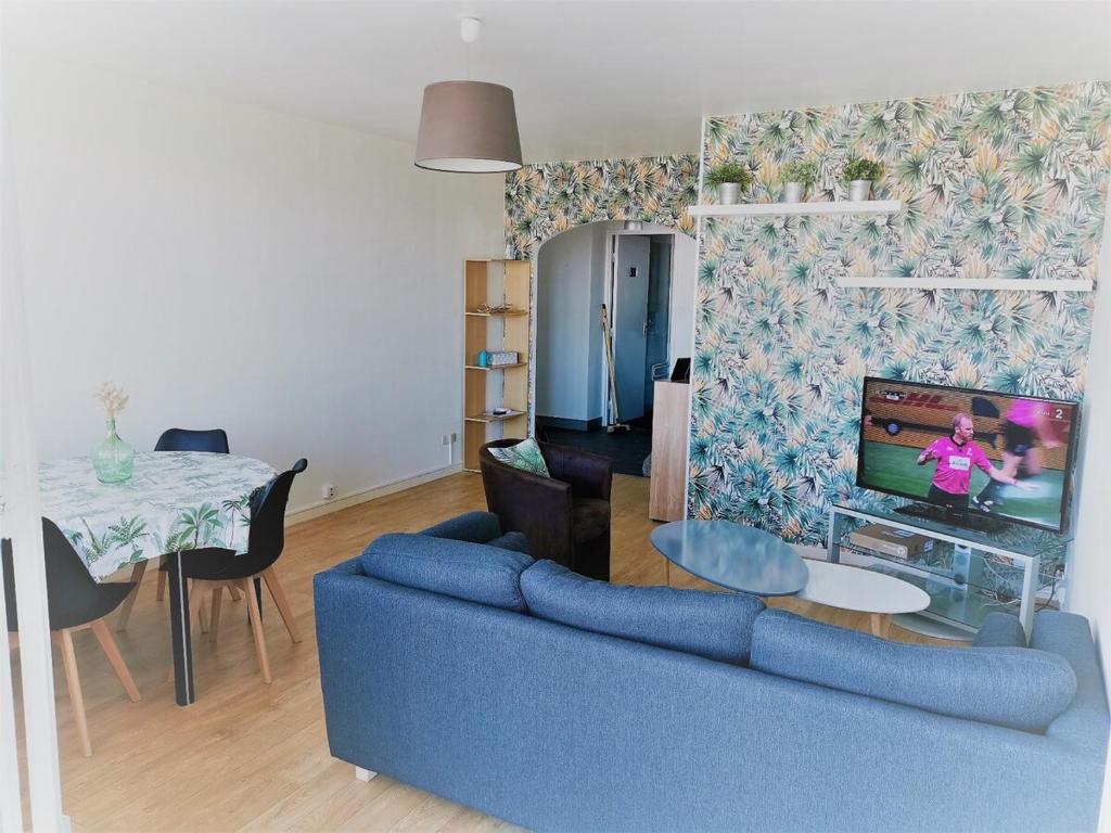 un salon avec un canapé bleu et une télévision dans l'établissement Spacious apartment bellevue, à Brest