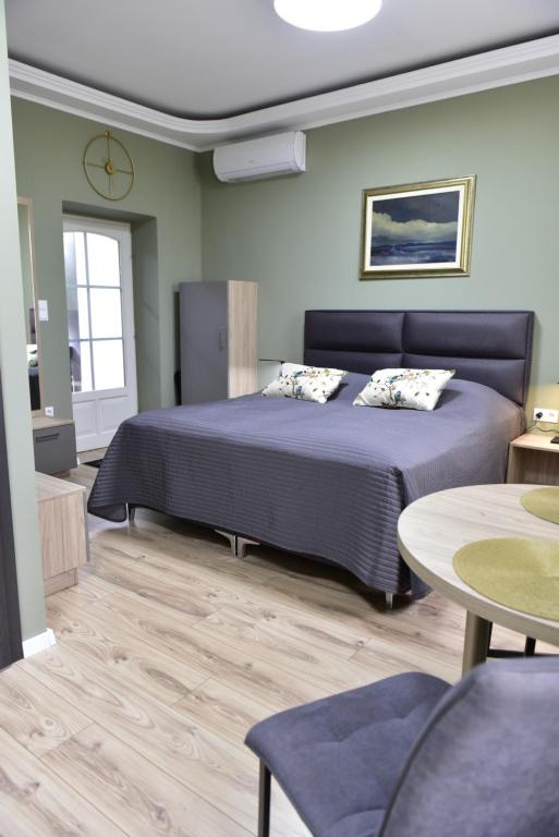 a bedroom with a large bed and a table at Tornácos Vendégház Kőröshegy in Kőröshegy