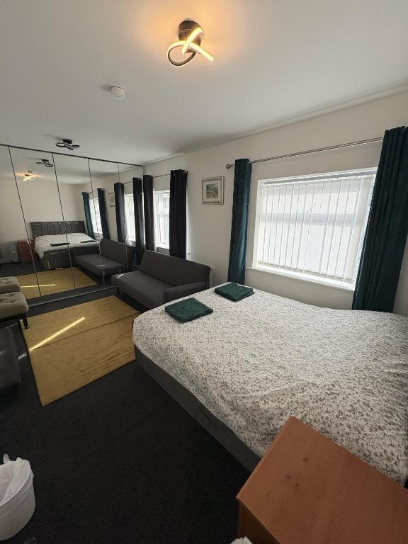 a bedroom with a bed and a couch and a mirror at Liberty Guest House in Liverpool