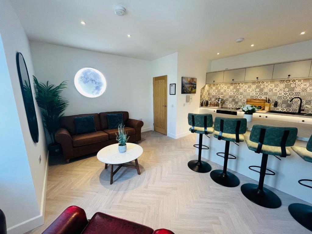 Una cocina y una sala de estar con un sofá y una mesa. en Bramble Apartment, en Fort William