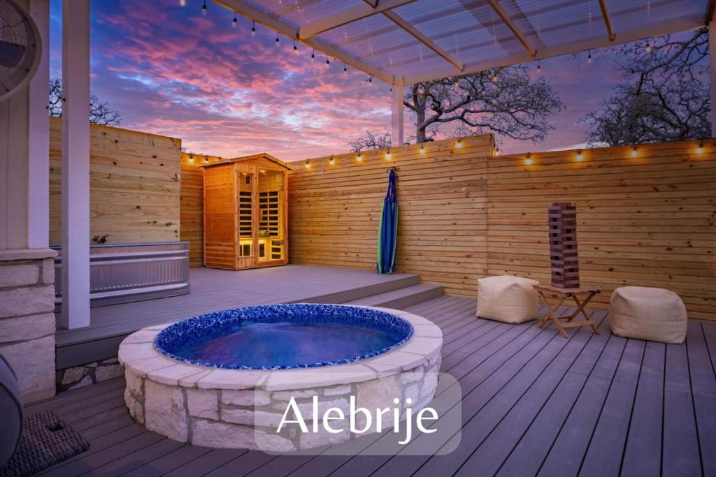 a patio with a hot tub on a wooden deck at Secluded Luxury Couples cabin Sauna Pool in Wimberley