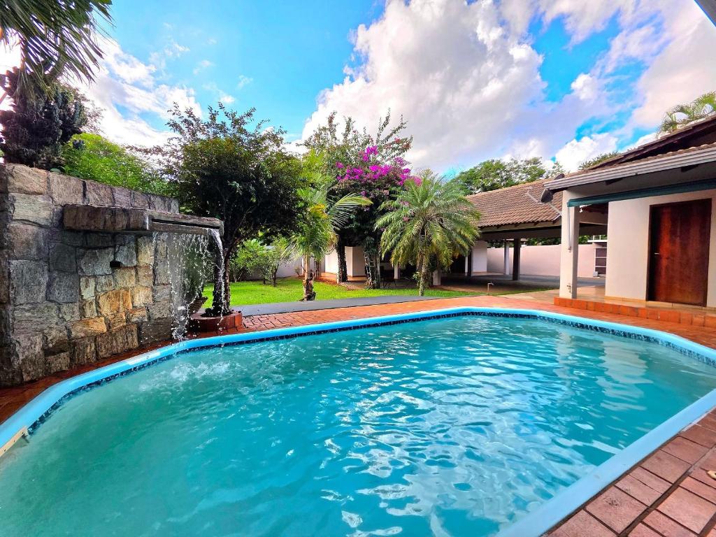 a swimming pool with a waterfall in a yard at 7 quartos - ótima área de lazer prox Centro e Cataratas in Foz do Iguaçu