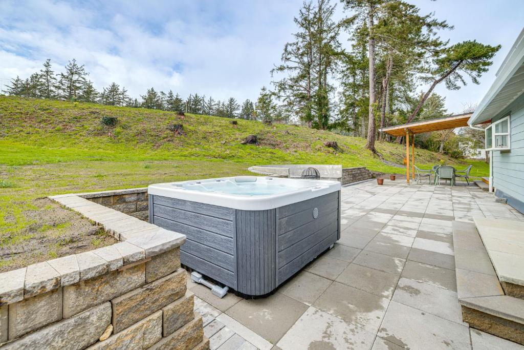una vasca idromassaggio su un patio accanto a una casa di 3 Mi to Beach Oregon North Coast Retreat a Warrenton