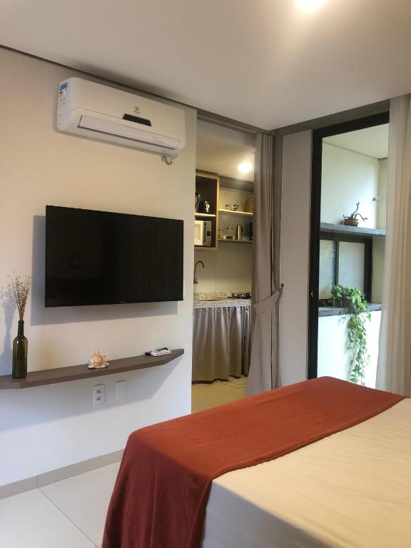 a bedroom with a flat screen tv on the wall at Loft Vila Murici in Flecheiras