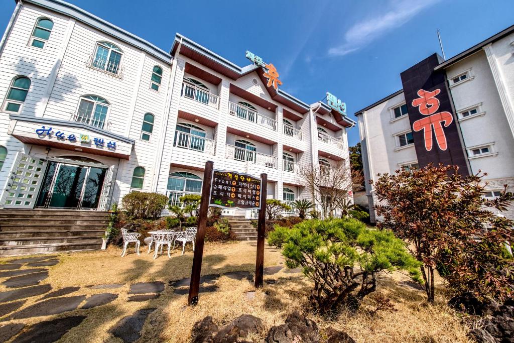 a building with a sign in front of it at Jeju Hue Pension in Seogwipo