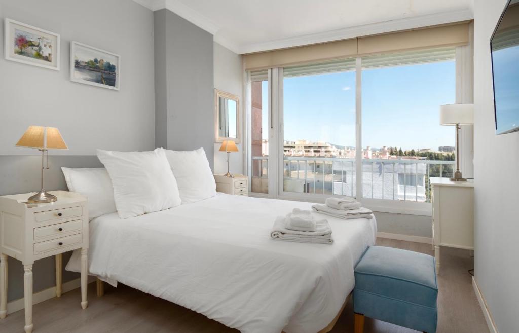 een slaapkamer met een wit bed en een groot raam bij Marea Living Marbella in Marbella