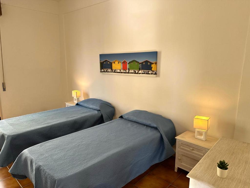 Palizzi MarinaにあるLa Casa di Mico - Appartamenti Mare e Soleのベッドが2つあり、壁に絵が飾られた寝室