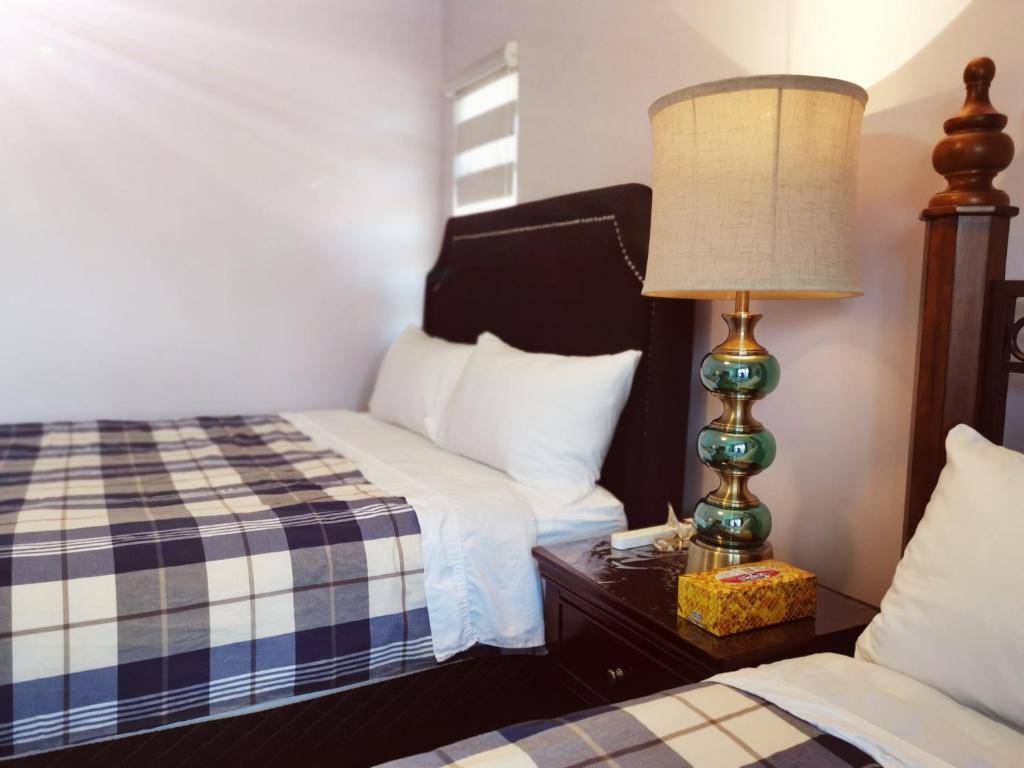 a bedroom with two beds and a lamp on a nightstand at Bed Plus YVR in Richmond