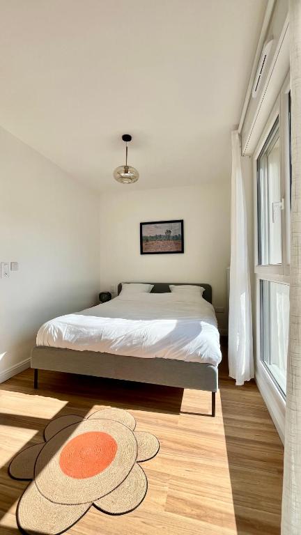 une chambre avec un lit et un tapis au sol dans l'établissement Maison 88 Malakoff, à Malakoff