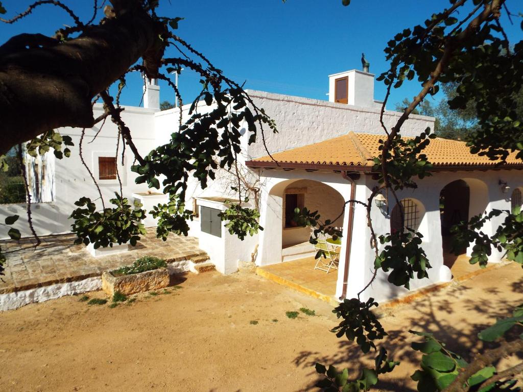 a white house with a courtyard and an archway at masseria LAMA DI GALIZIA in Ostuni