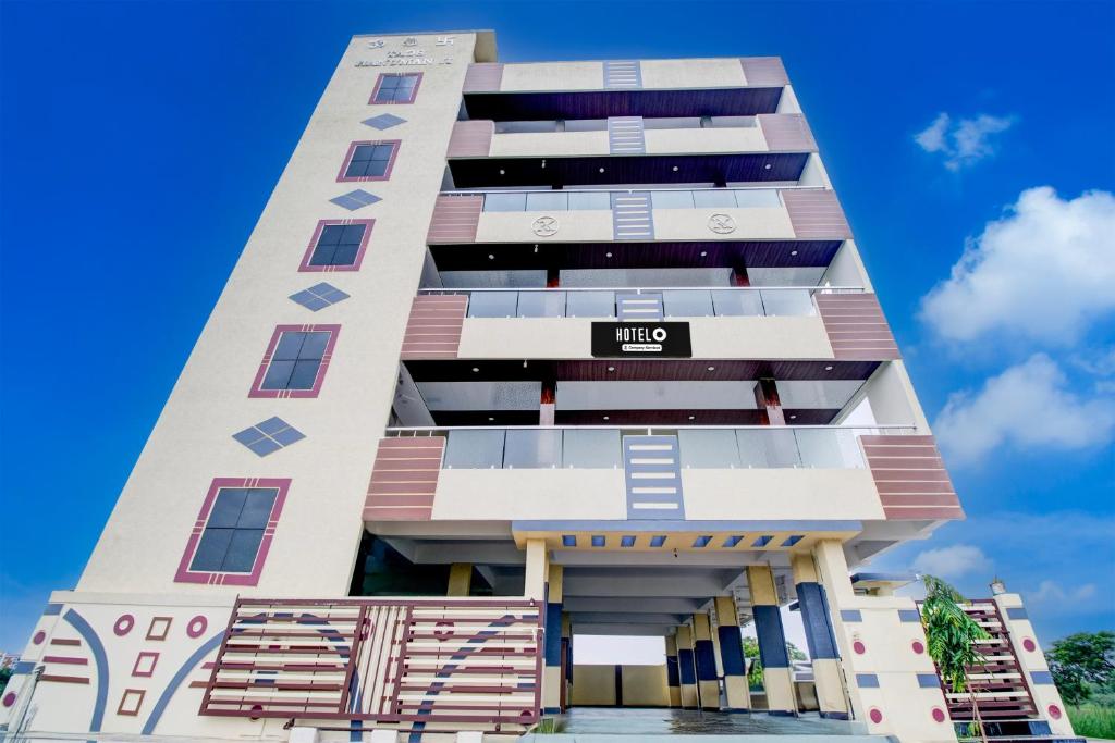 a tall building with a blue sky in the background at Hotel O Ramavarapadu Near PVR Icon in Vijayawada