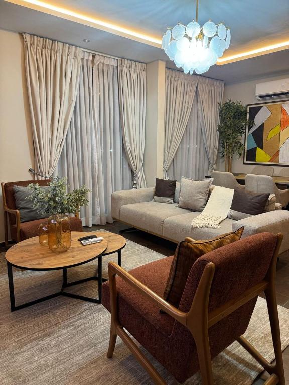 a living room with a couch and a table at Apartment Opal At The Park in Accra