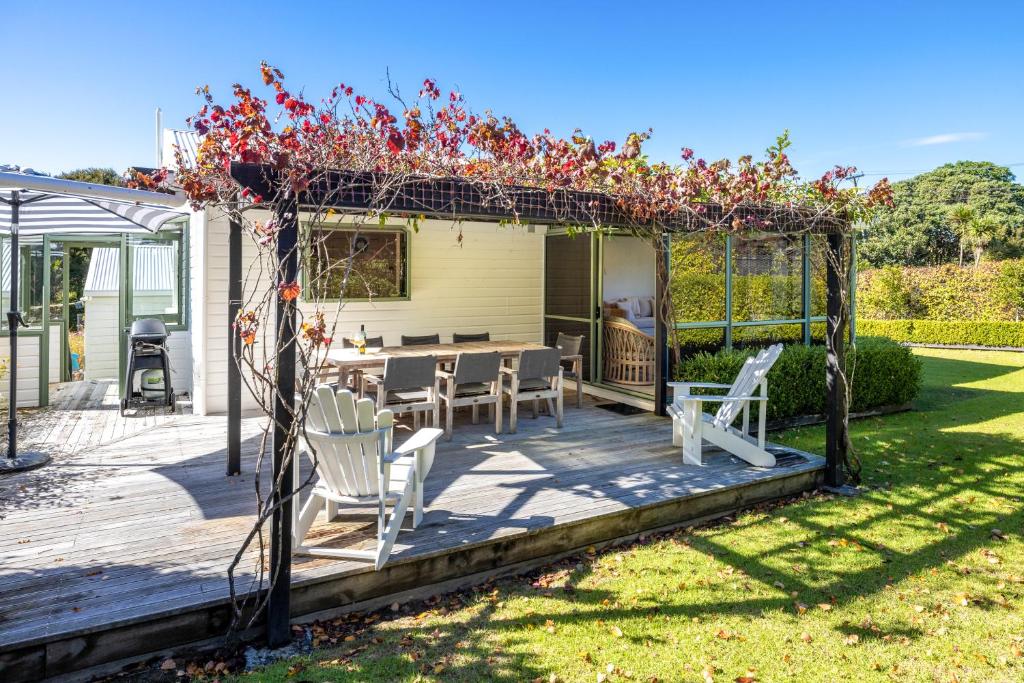 une terrasse avec une pergola, une table et des chaises dans l'établissement Tranquility Cottage, Oneroa - Be My Guest Waiheke, à Waiheke Island