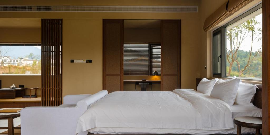 Postel nebo postele na pokoji v ubytování Huangshan Yixian Pumanmanju Hotel