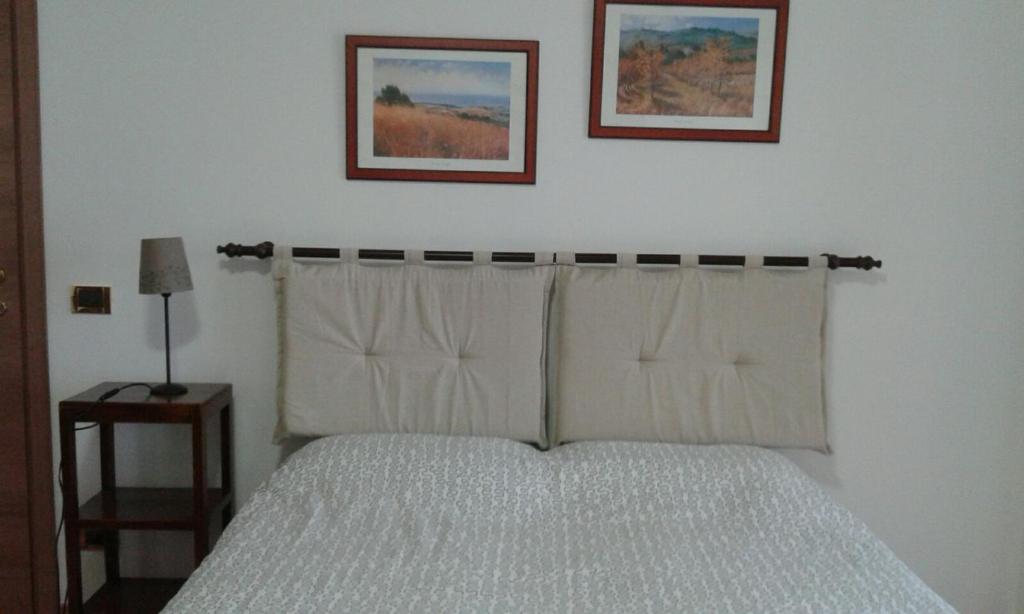 ピエーヴェ・リーグレにあるIl Gabbiano Di Pieveのベッドルーム1室(ベッド1台付)が備わります。壁に2枚の写真が飾られています。