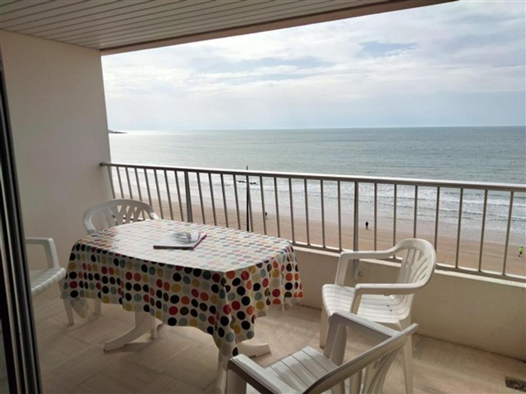 un balcon avec une table et des chaises et l'océan dans l'établissement Appartement T3 avec Terrasse Centre Plage - FR-1-331-33, à Les Sables-dʼOlonne