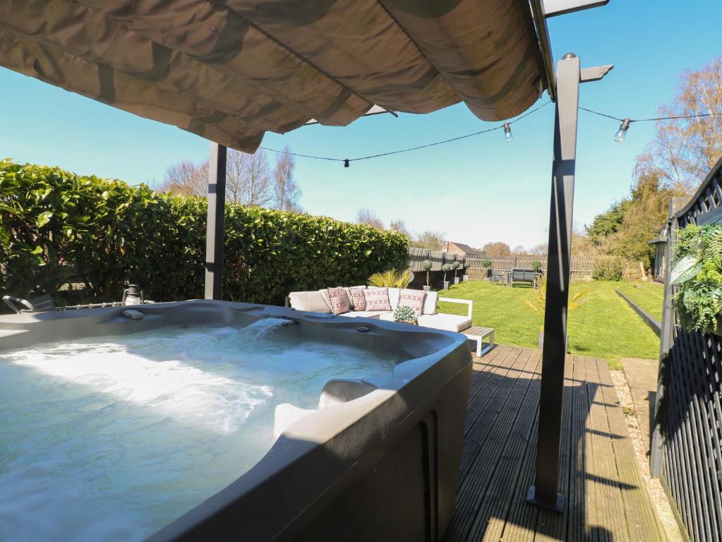 ein Whirlpool auf einer Terrasse mit Blick auf einen Garten in der Unterkunft Coupling Cottage in Belper